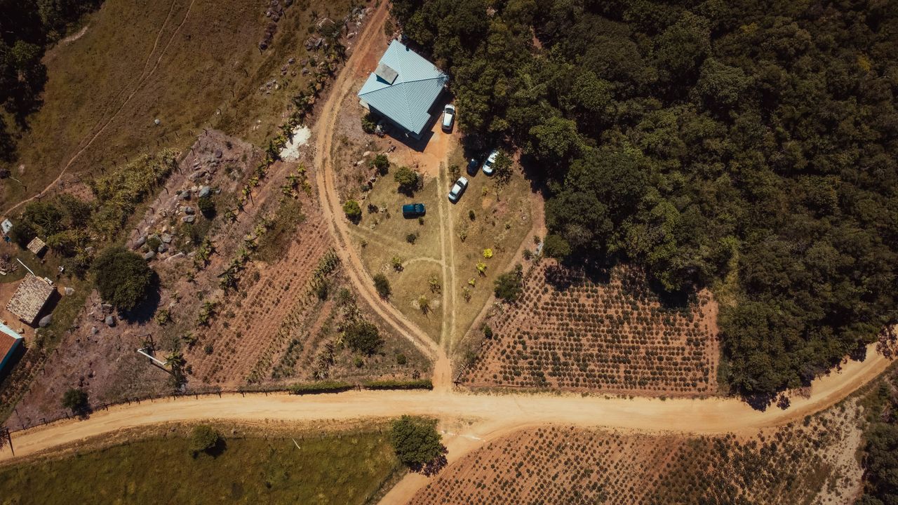 services-02 Aerial view of a rural countryside with a house and fields in Tubarão, Brazil.